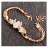 Pulsera dorada con una piedra brillante en el centro y pequeños destellos a los lados.