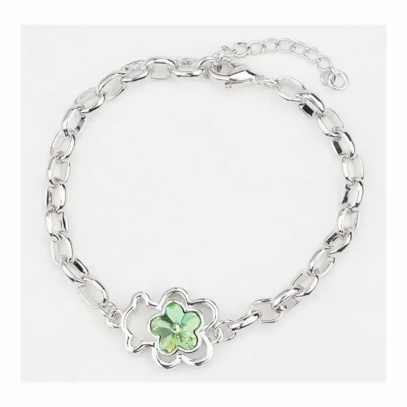 Brazalete dorado con un oso verde esmaltado como pieza central.