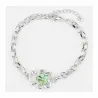 Brazalete dorado con un oso verde esmaltado como pieza central.