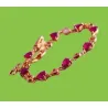 Pulsera de bisutería en oro rosa con piedra roja de imitación rubí, mostrando su brillo sobre la piel.