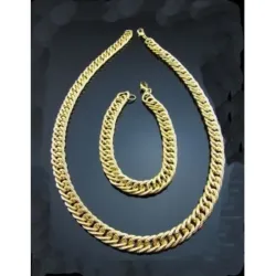 Conjunto de bisutería con collar y pulsera de cadenas doradas, mostrando su brillo y textura sobre un fondo neutro