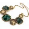 Collar de bisutería vintage en acero dorado con piedras verdes, mostrando su diseño barroco y brillo facetado.