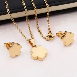 Set collar y pendientes bisutería mujer con trébol de cuatro hojas acabado oro 18k sobre fondo blanco.