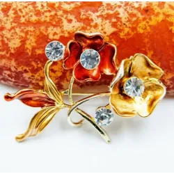 Broche chapado en oro con cristales y rosa de acero color dorado.