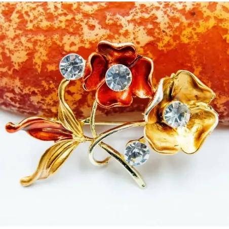 Broche chapado en oro con cristales y rosa de acero color dorado.