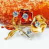 Broche chapado en oro con cristales y rosa de acero color dorado.
