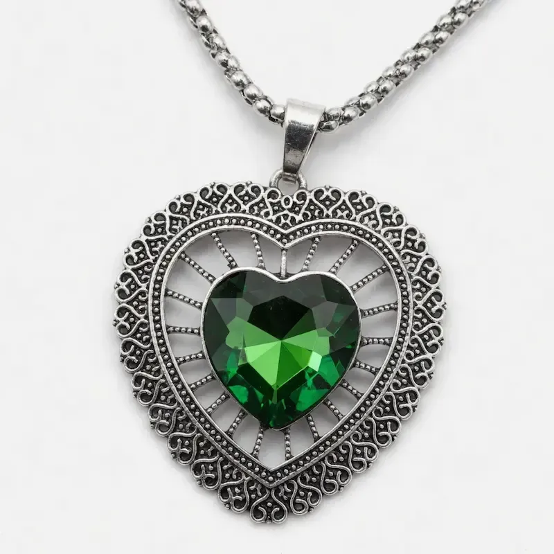Collar con corazón y piedra central verde. Cristal facetado color esmeralda