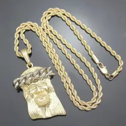 Colgante Jesús bisutería hombre con rostro 5,5cm oro 18K y cadena 4mm, sobre fondo negro.