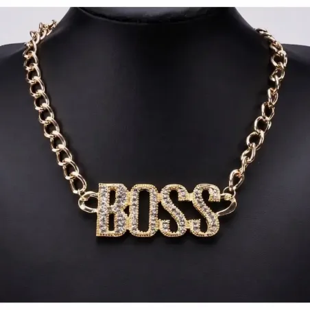 Collar bisutería hombre estilo hip hop con colgante grande dorado y cristales, sobre fondo oscuro.