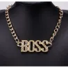 Collar bisutería hombre estilo hip hop con colgante grande dorado y cristales, sobre fondo oscuro.