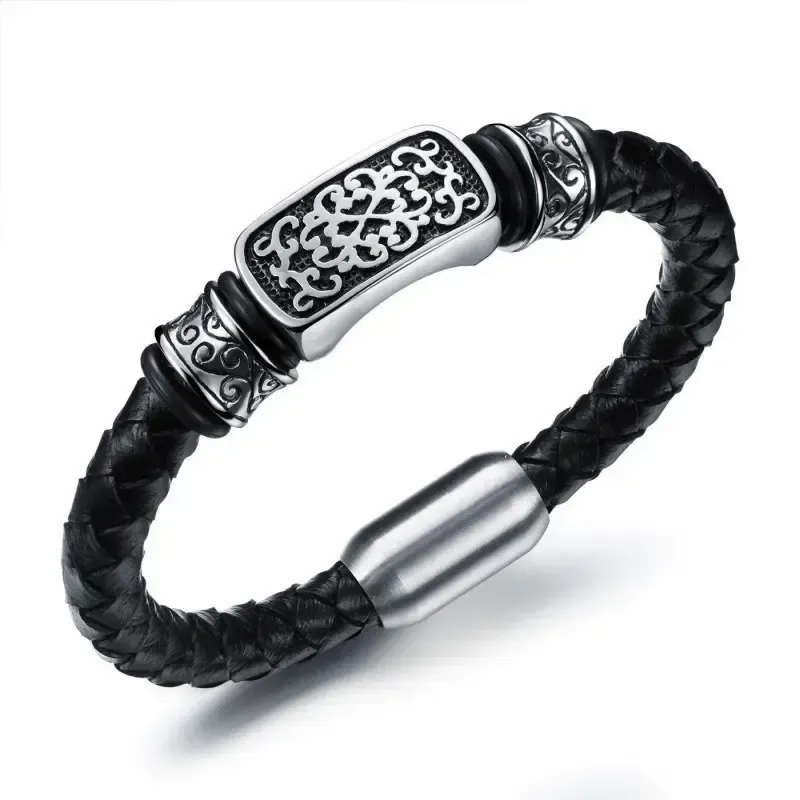 Pulsera bisutería hombre en titanio y piel negra con cierre magnético y detalle central plateado, sobre fondo neutro.