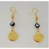 Pendientes bisutería mujer con monedas doradas y ojos turcos chapado oro, sobre fondo azul noche.