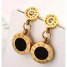 Pendientes bisutería mujer redondos con números romanos y circonitas acabado oro 18k, sobre fondo blanco.
