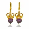 Pendientes bisutería mujer con corazón púrpura cristal 3cm gold filled 18K, sobre fondo rosa suave.