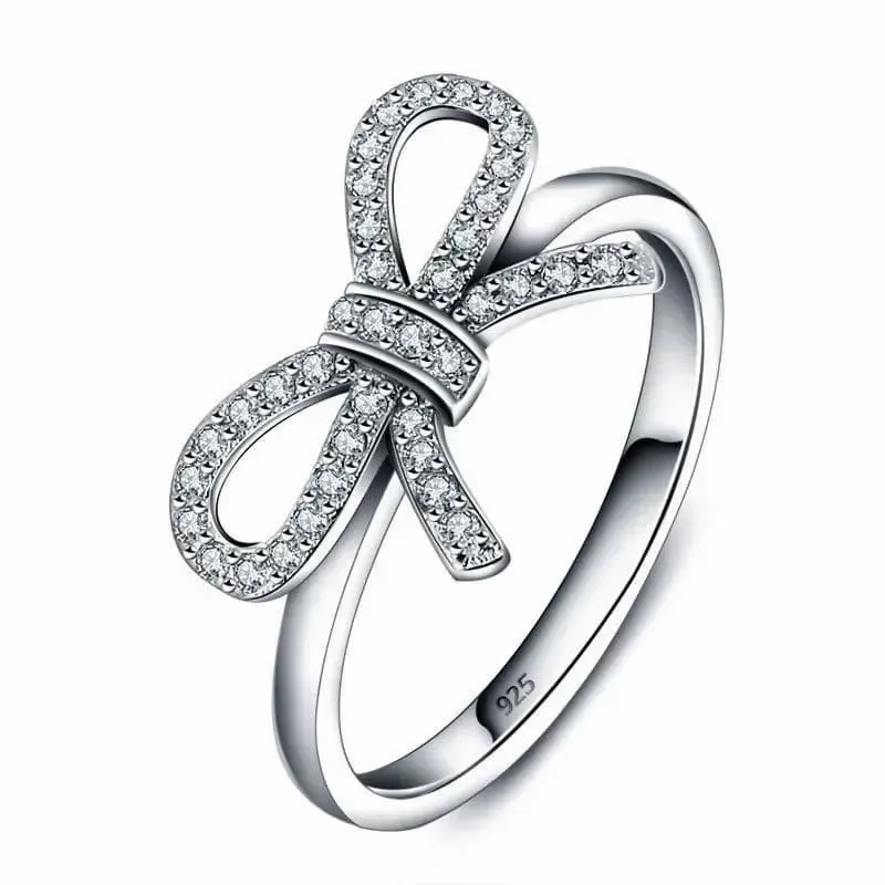 Anillo de plata de ley 925 con diseño de lazo entrelazado y piedras blancas incrustadas.