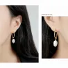 Pendientes de plata esterlina con acabado dorado y perla barroca blanca de forma irregular, acabado brillante.