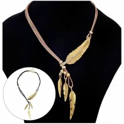 Colgante dorado con forma de pluma colgando de un cordón de piel marrón.
