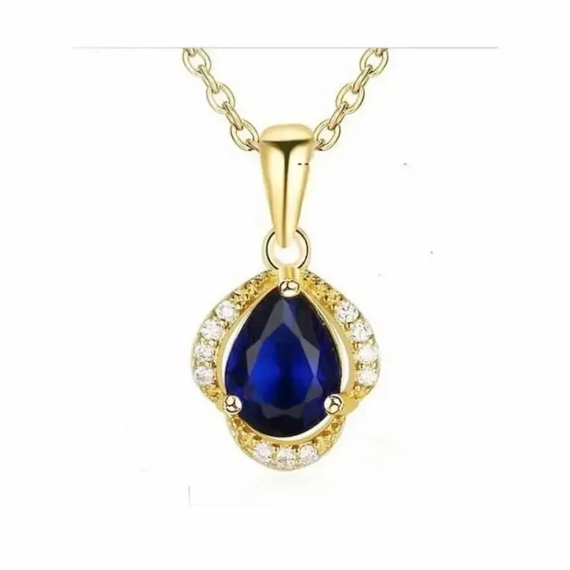 Colgante de cristal azul brillante con pequeños destellos en una cadena dorada fina.