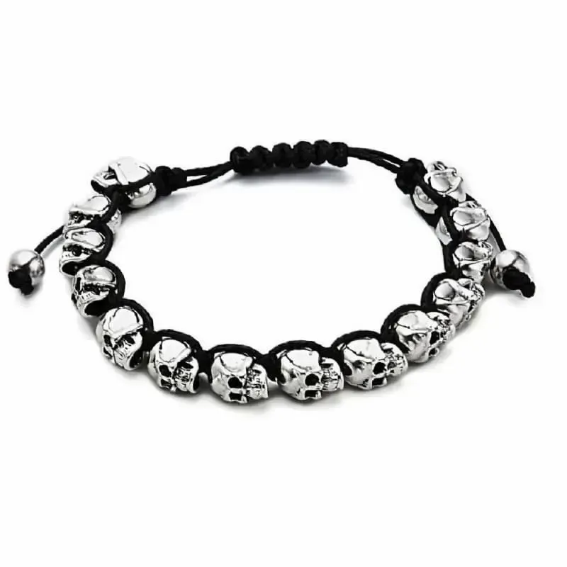Brazalete de hilo negro con dos calaveras plateadas y cierre ajustable.
